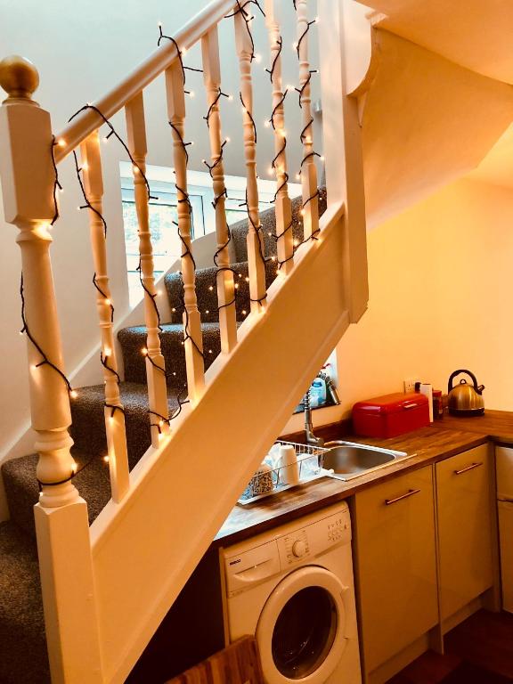 a kitchen with a staircase with a washing machine at Garden Oasis in Margate