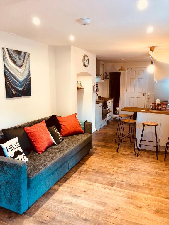 a living room with a couch and a kitchen at Garden Oasis in Margate