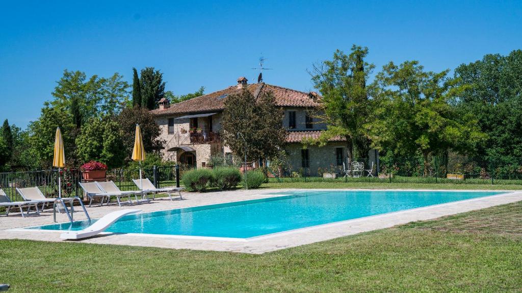 a house with a swimming pool in front of a house at La Stalla in Acquaviva