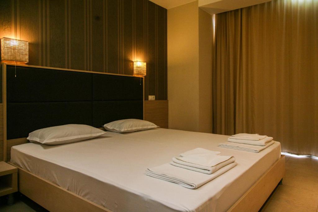 a bedroom with a large bed with towels on it at Apart-Hotel Onegin & Thermal Zone in Sozopol