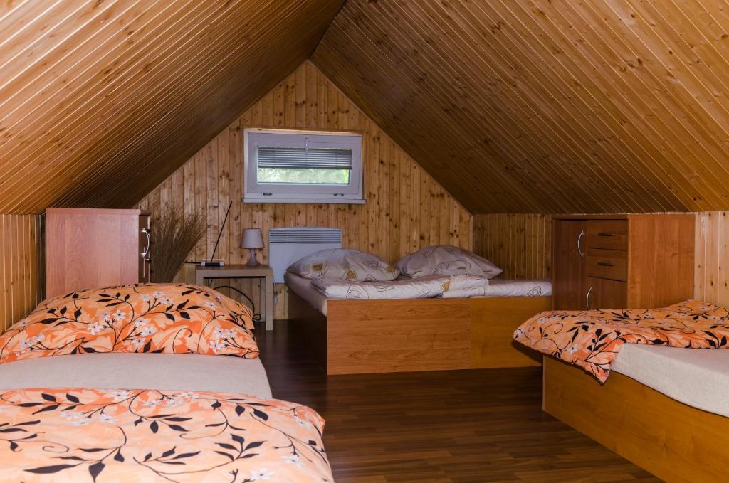 a bedroom with two beds in a attic at Sklep u Malíků in Drnholec