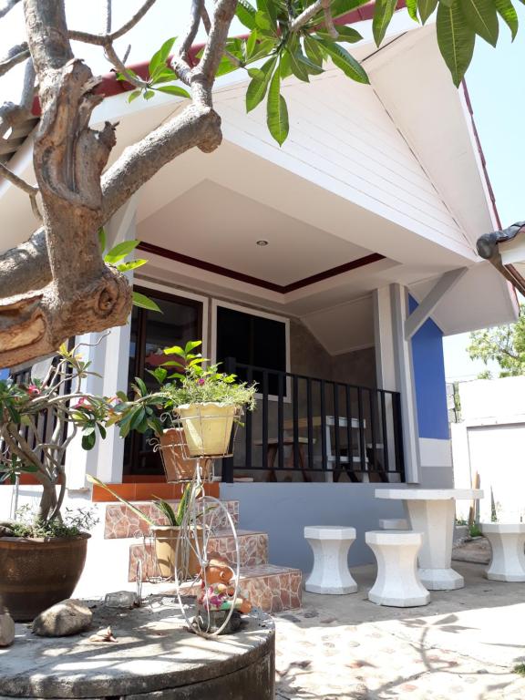 a front porch of a house with potted plants at Poopreaw Koh Larn in Ko Larn
