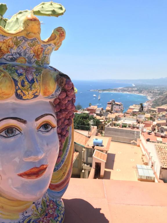 a statue of a woman with a vase on her head at Amartìa Apartments in Taormina