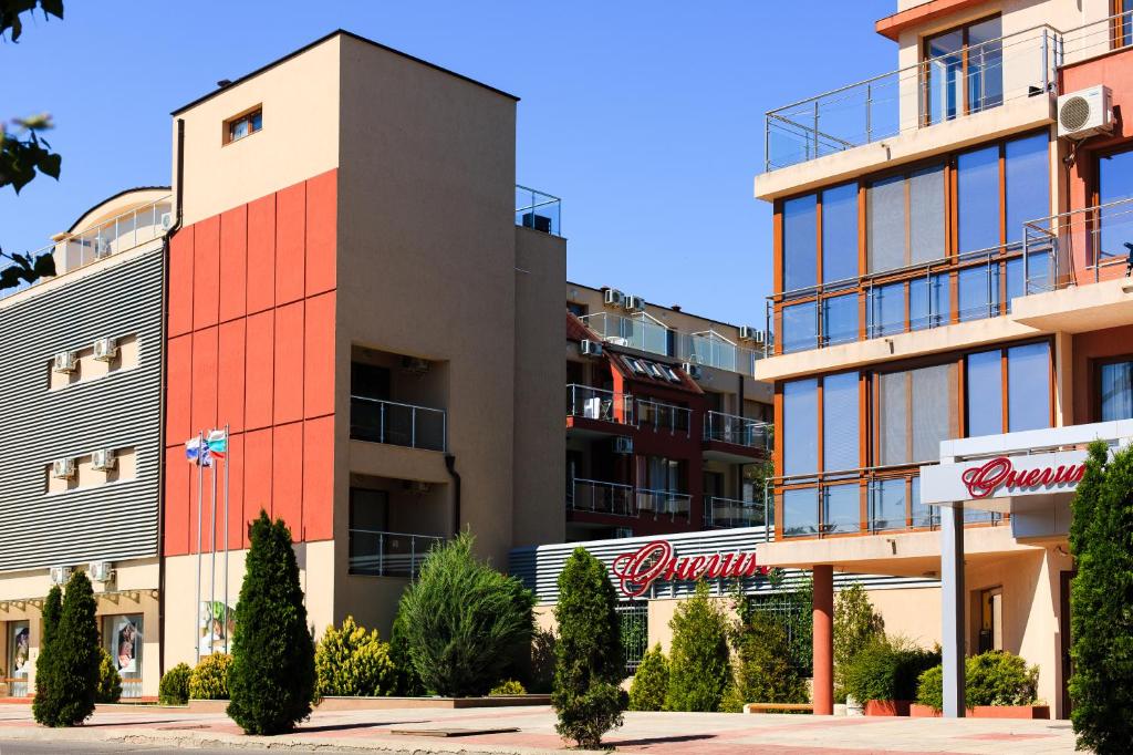 a building with a red stripe on the side of it at Apart-Hotel Onegin & Thermal Zone in Sozopol