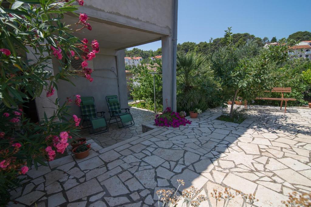 a patio with chairs and flowers next to a building at Anastasia 3 in Veli Lošinj