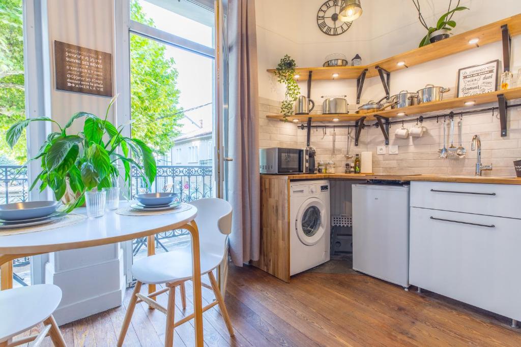 a kitchen with a table and a washing machine at Studio Clemenceau in Aix-les-Bains