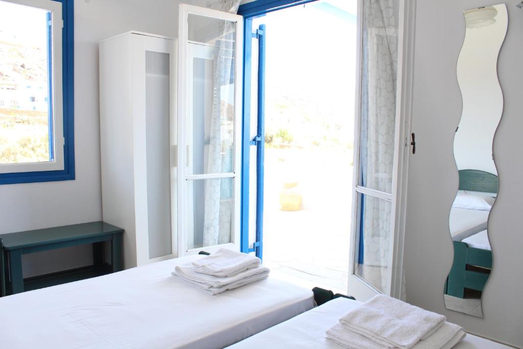 1 dormitorio con 2 camas y ventana en Mare Blue Ios, en Ios Chora