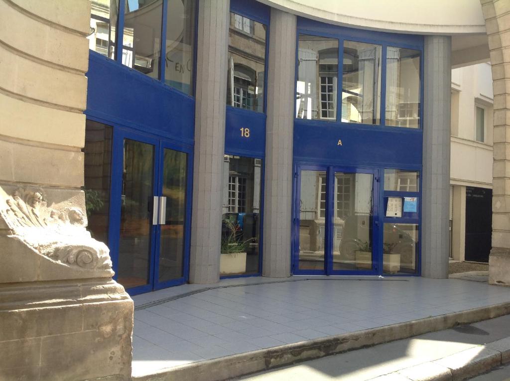 a large building with blue doors and windows at Studio centre de Bordeaux in Bordeaux
