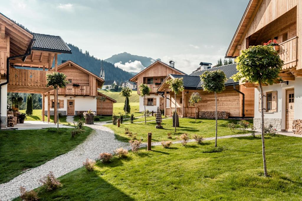 a garden in a village with wooden buildings at Pradel Dolomites in San Martino in Badia