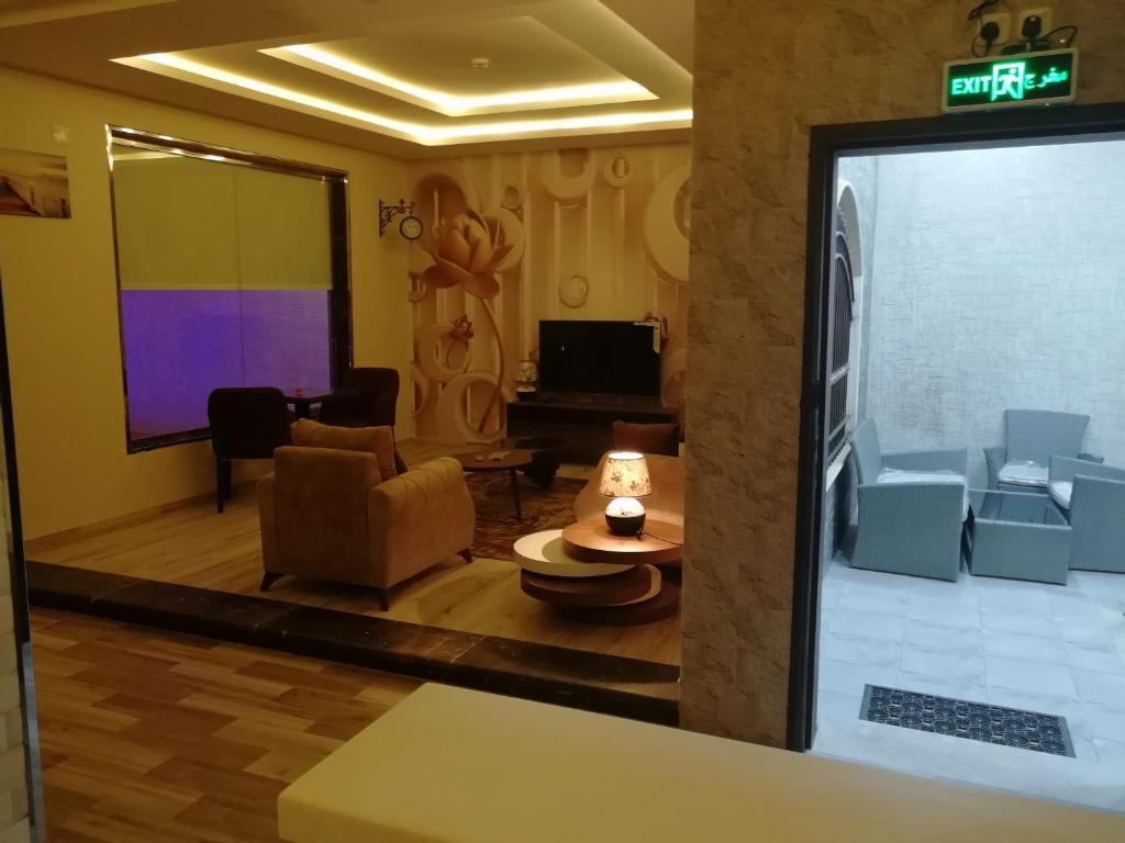 a living room with a couch and a projection screen at Al Worod Al Thahabia Chalets in Abha