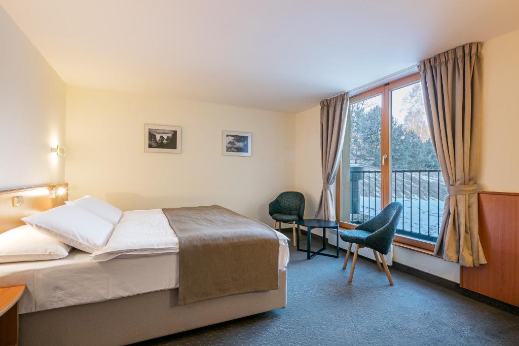 a hotel room with a bed and a balcony at Hotel Ostrov in Tisá