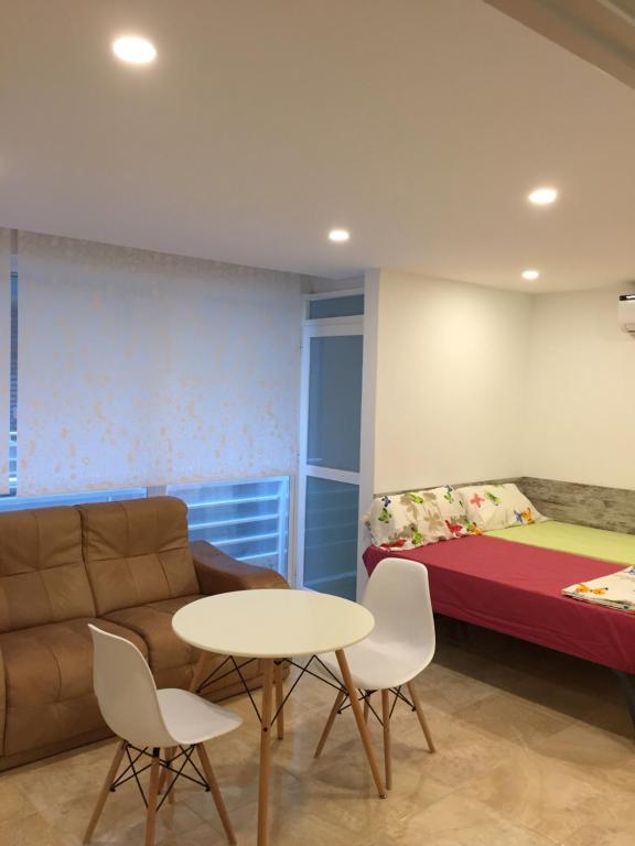 フエンヒロラにあるPasaje La Camboriaのソファ、テーブル、ベッドが備わる客室です。