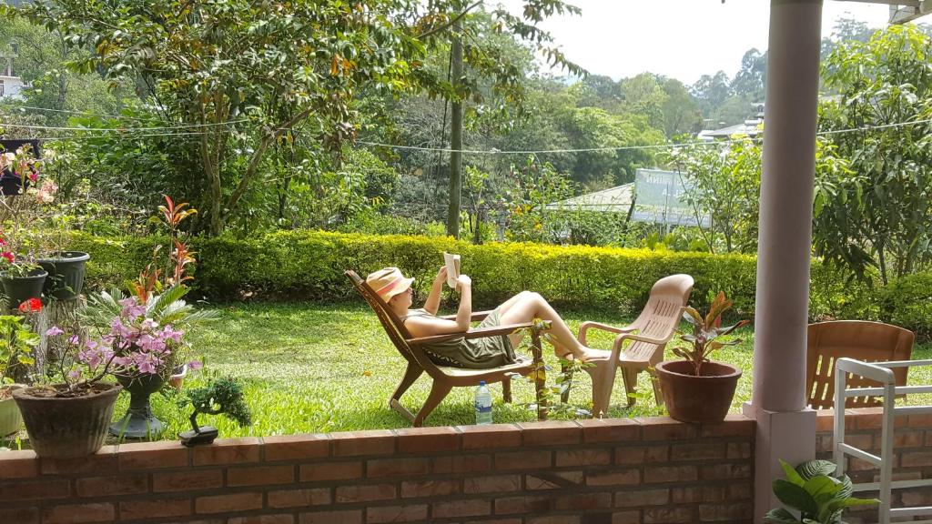 a woman laying in rocking chairs in a garden at 59B Rest Inn Ella in Ella