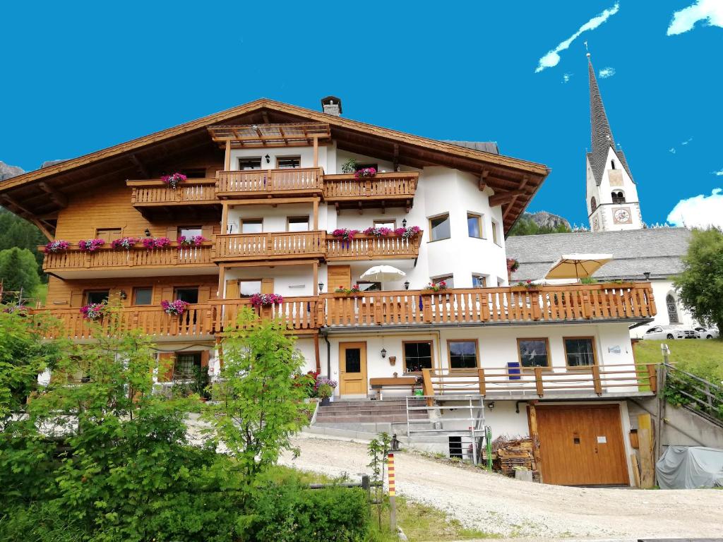 un grande edificio con balcone e chiesa di Garni Miriam a La Villa