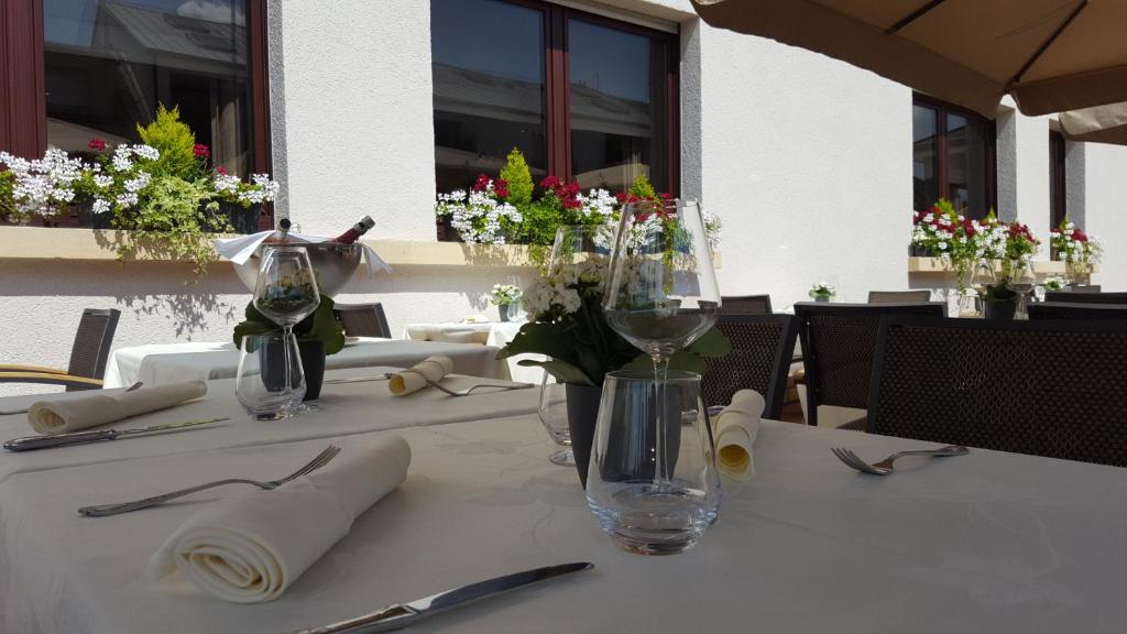 a table with wine glasses and flowers on it at Hotel Re'ser Stuff in Roeser