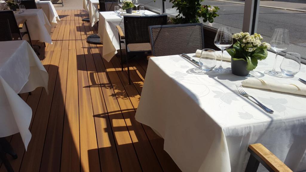 a row of tables with wine glasses and flowers at Hotel Re'ser Stuff in Roeser