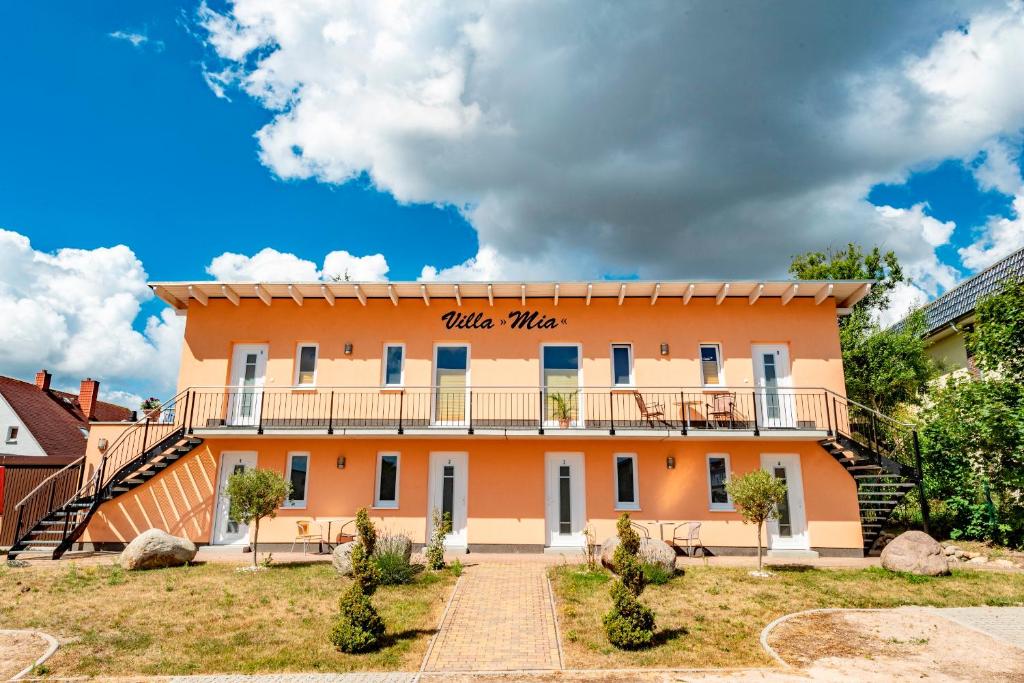ein großes orangefarbenes Gebäude mit Balkon in der Unterkunft Villa Mia Nr 1 mit Terrasse EG 1 Raum Wohnung in Göhren