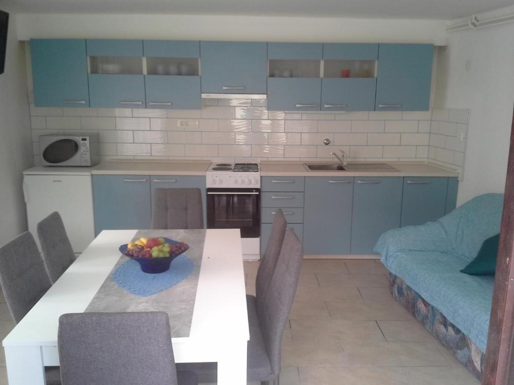 a kitchen with a table with a bowl of fruit on it at K21 Apartment in Bovec