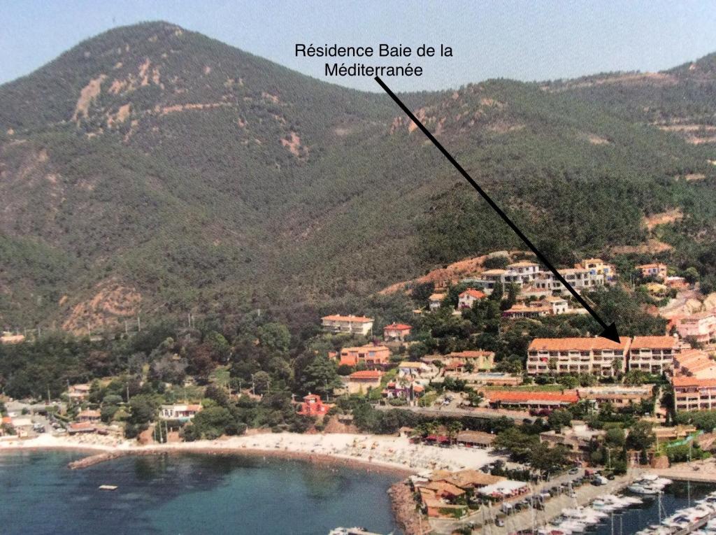 a view of a beach with mountains in the background at Plage de Miramar in Théoule-sur-Mer