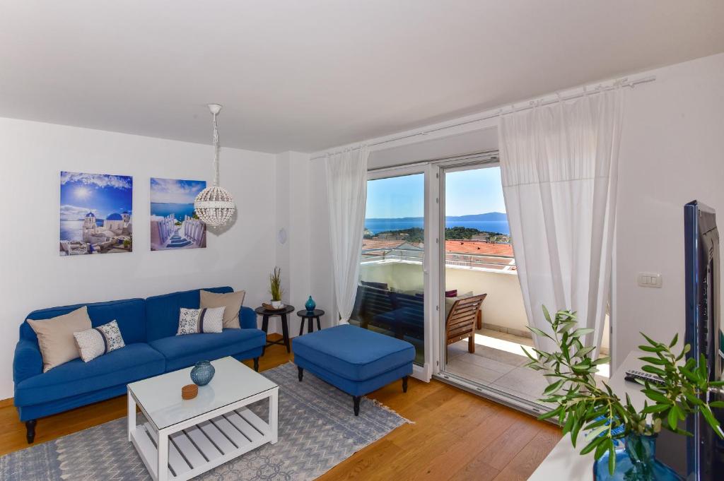 a living room with a blue couch and a large window at Apartment Ricca Seaview in Makarska