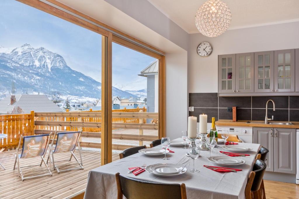 a dining room with a table and a view of a mountain at Apartment Briancon in Briançon