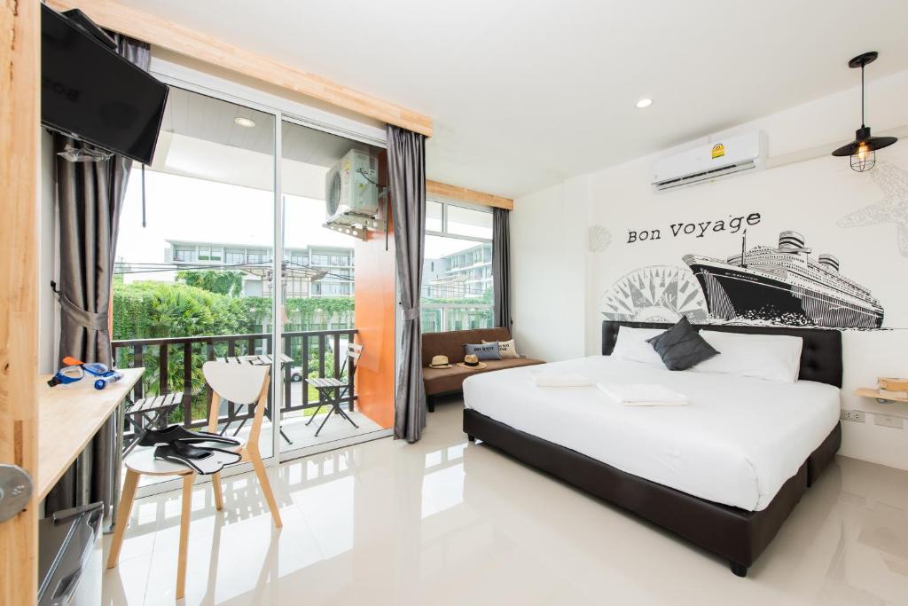 ナイヤンビーチにあるDwell Phuket Airport Hotel at Naiyangのベッドルーム(ベッド1台付)、バルコニーが備わります。
