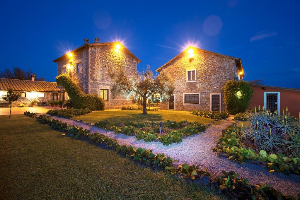 una gran casa de piedra por la noche con luces en I Casali della Parata en Velletri