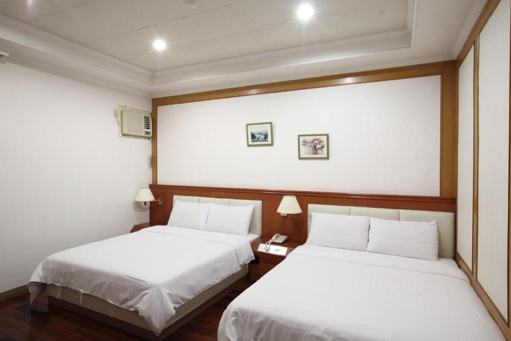 Postel nebo postele na pokoji v ubytování Long Shan Hotel