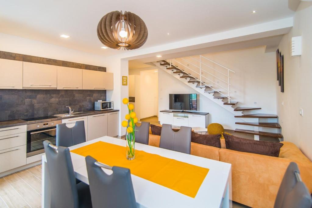 eine Küche und ein Wohnzimmer mit einem Tisch und Stühlen in der Unterkunft Milohanic Luxury Porec Apartments in Poreč