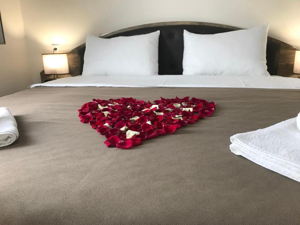 a heart made out of red roses on a bed at Sweet Rooms Inn in Tbilisi City