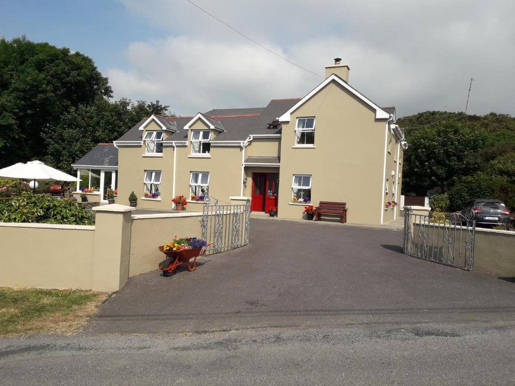 a large yellow house with a fence in front of it at Atlantic House B&B in Castletownshend