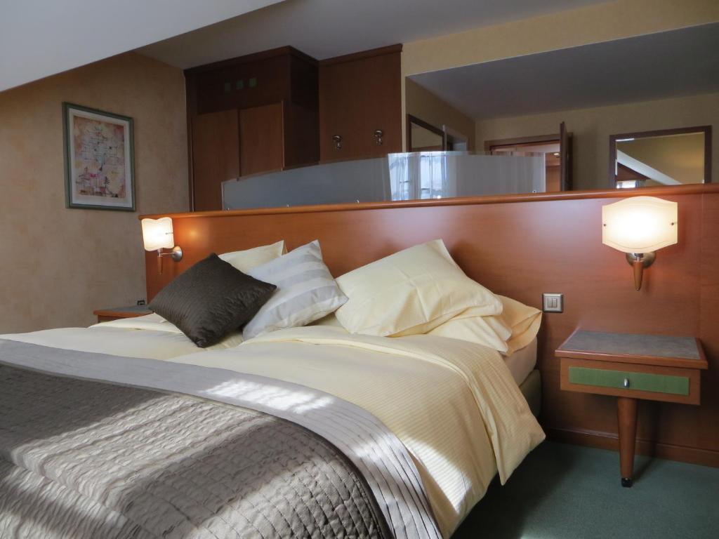 a bedroom with a large bed with a wooden headboard at Hôtel du Port in Lausanne