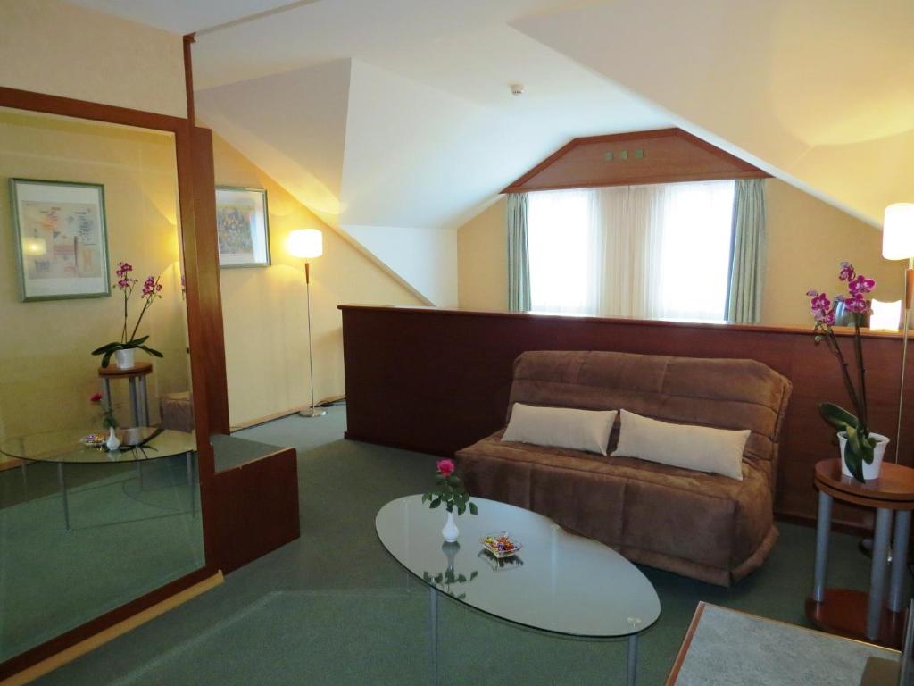 a living room with a couch and a table at Hôtel du Port in Lausanne