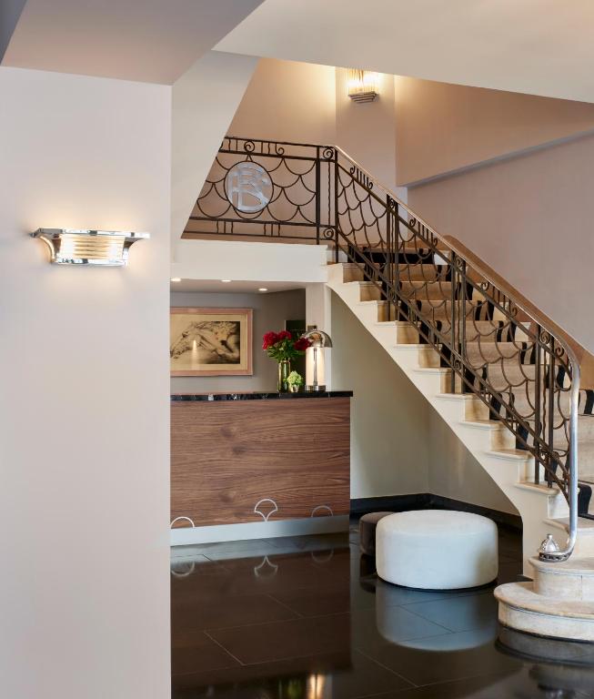 a staircase in a home with a white stair case at Hôtel Les Roches Blanches Cassis in Cassis