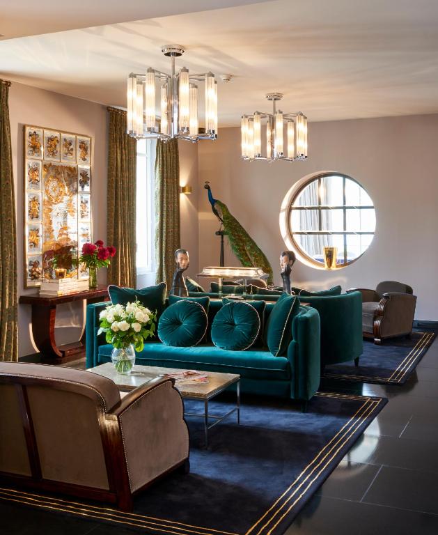 a living room with a blue couch and a table at Hôtel Les Roches Blanches Cassis in Cassis
