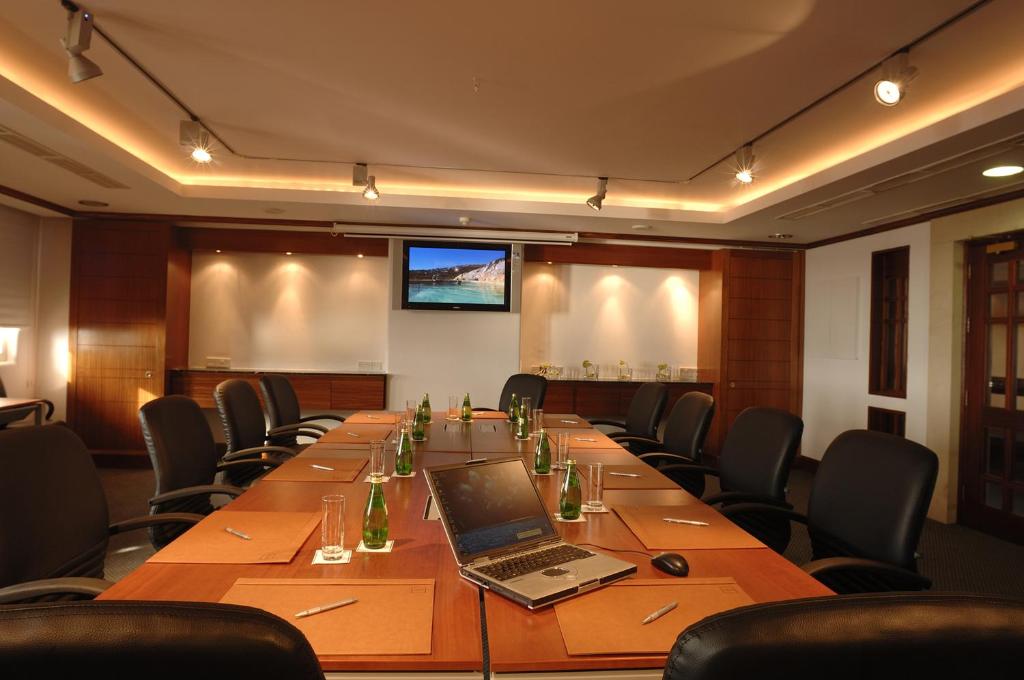 a conference room with a long table with a laptop on it at Thalassa Boutique Hotel & Spa in Coral Bay