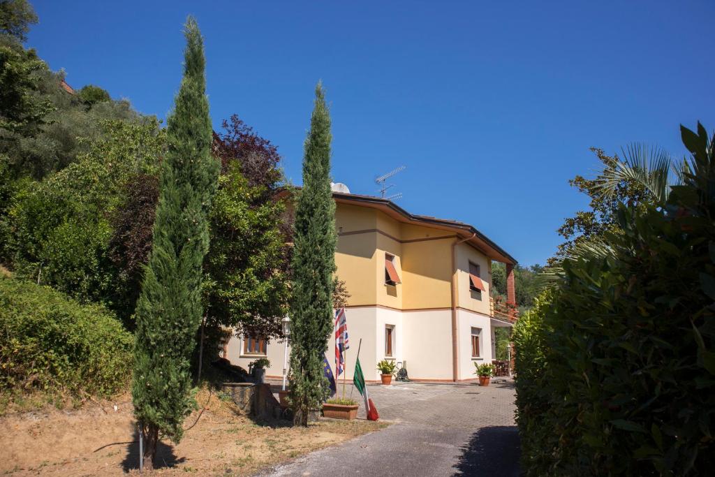a house with trees in front of a road at Morianese Residence in Lucca