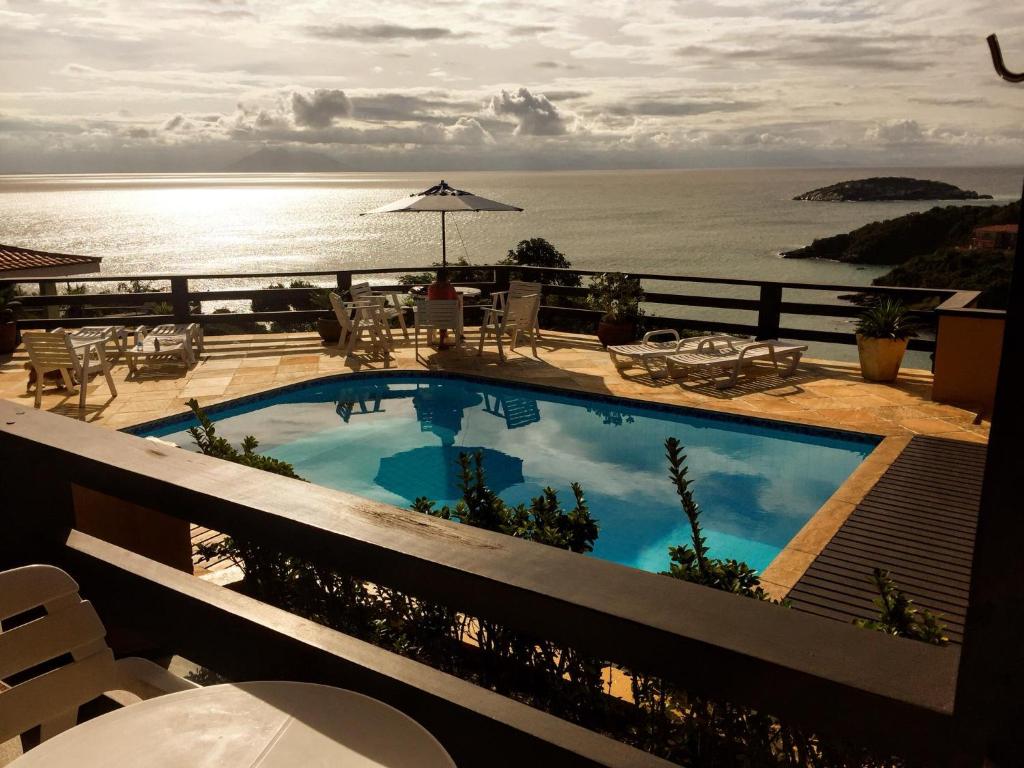 a swimming pool with a view of the ocean at Pousada Gente Bonita Mirante in Búzios