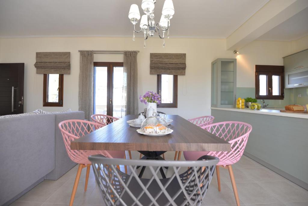 comedor con mesa y sillas rosas en Lidromi Home (Blue), en Centro histórico de Alónnisos