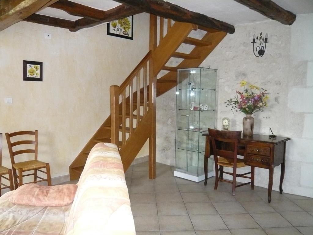 a bedroom with a staircase and a table and a desk at La grange de Candé in Monts