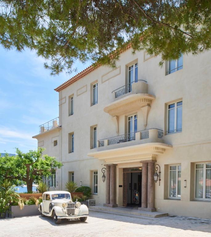 an old car parked in front of a building at Hôtel Les Roches Blanches Cassis in Cassis