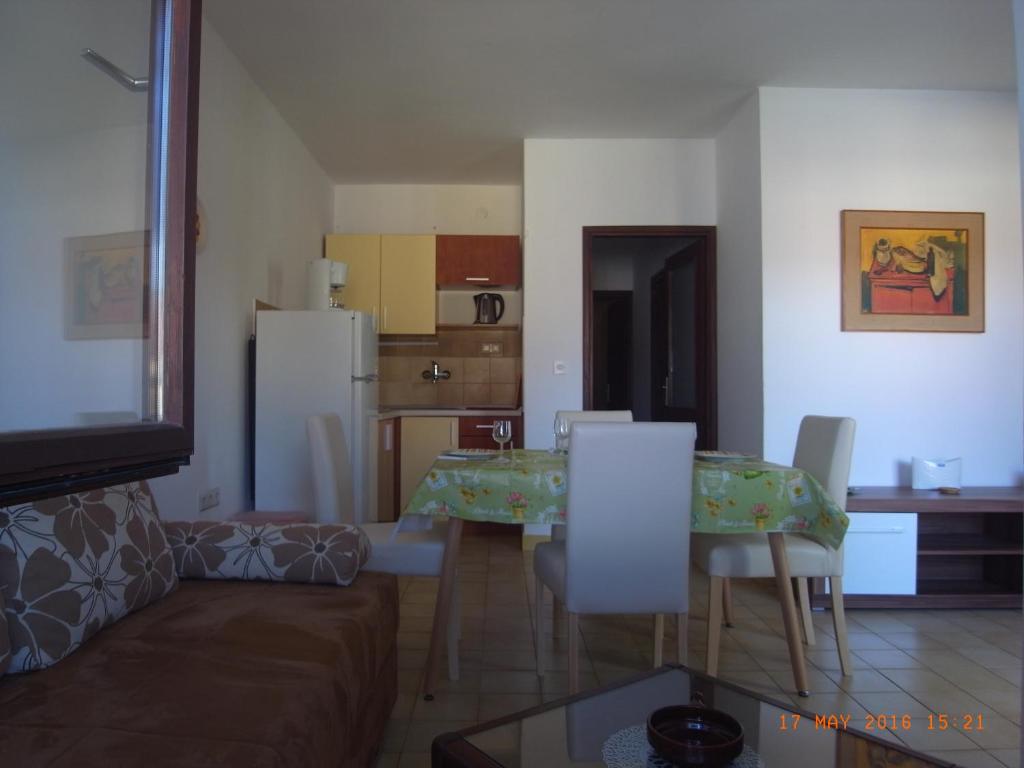 sala de estar con mesa y sillas y cocina en Apartmani MW , Zuti apartman, en Baška