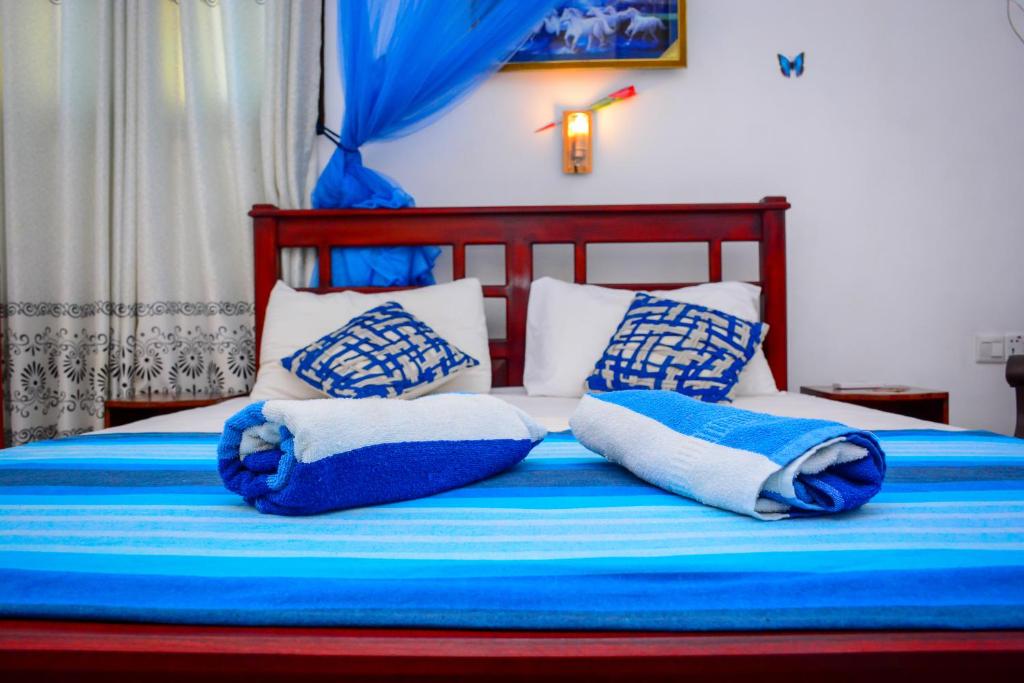 Una cama con almohadas azules y blancas. en Joseph Family Villa, en Negombo