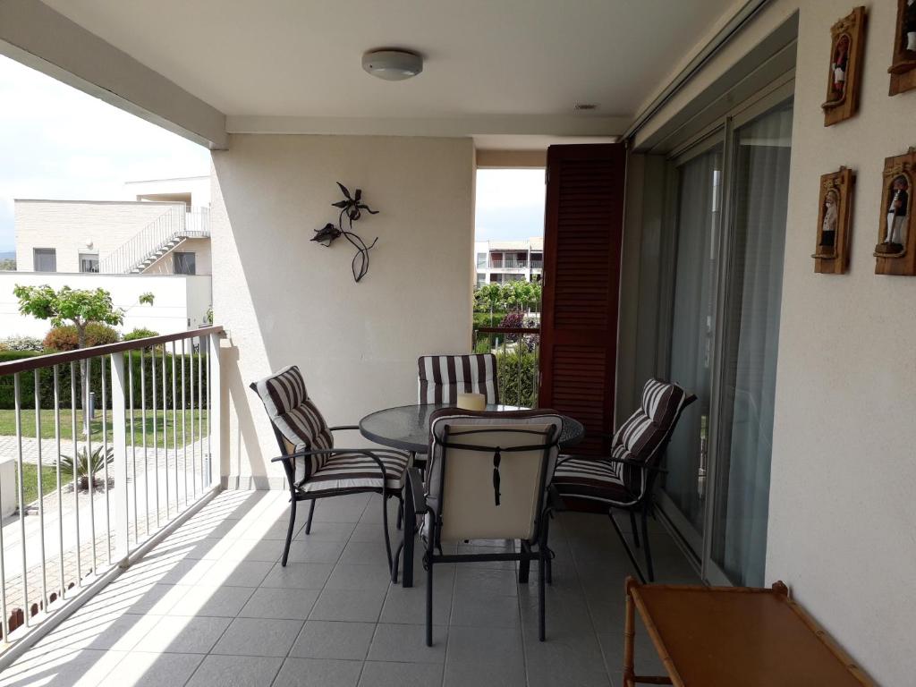 patio ze stołem i krzesłami na balkonie w obiekcie Sant Jordi club de golf apart 4 x 2 w mieście Sant Jordi