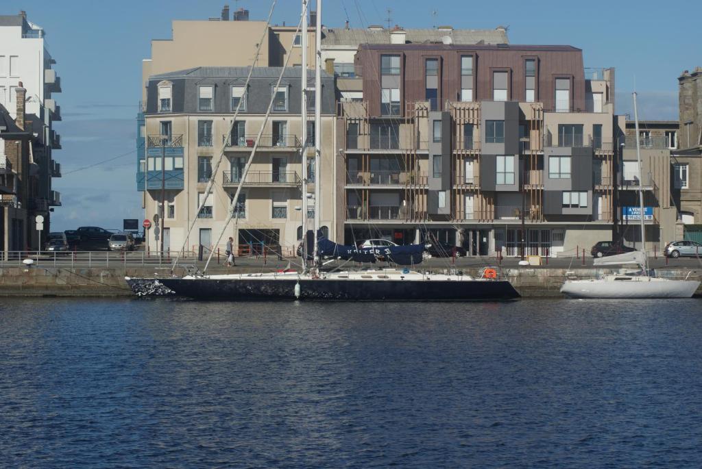 ein Boot im Wasser neben den Gebäuden in der Unterkunft Appartement Quai Sud in Saint-Malo