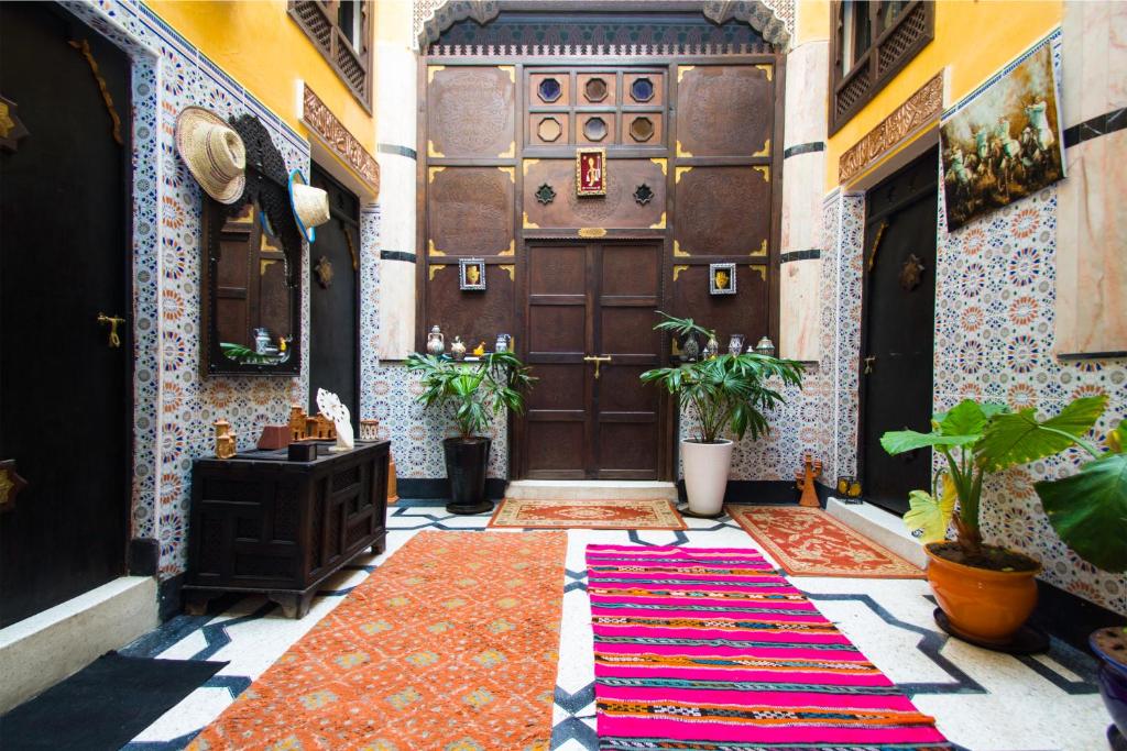 an entrance to a building with a door and a rug at Dar Berrada - Ziat in Fès