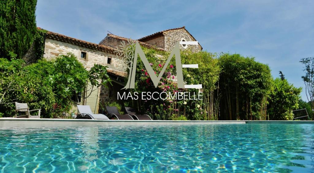 a villa with a swimming pool in front of a house at Mas Escombelle in Barjac