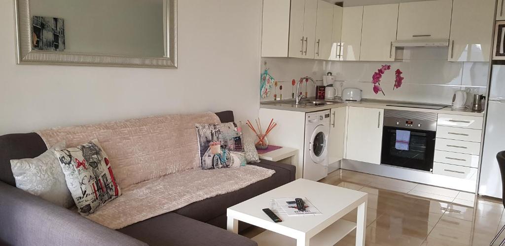 a living room with a couch and a kitchen at Paradise Club L28 & L29 in Puerto del Carmen