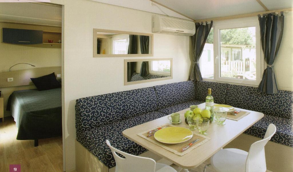 a small dining room with a table and a couch at New Camping Le Tamerici in Marina di Cecina