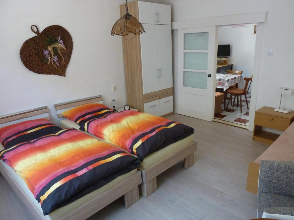 Un dormitorio con una cama con sábanas coloridas. en Schöne, gemütliche Wohnung, en Katzhütte